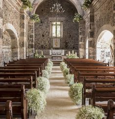 the inside of an old church with pews and flowers on each side of the aisle