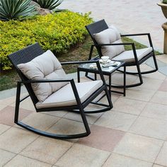 two rocking chairs sitting next to each other on top of a brick floor covered patio