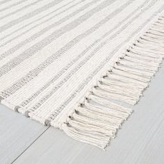 a white rug with fringes on the floor