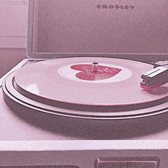 an old record player sitting on top of a turntable in a room with pink walls