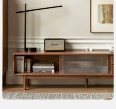 a wooden shelf with books, radio and other items on top of it in a living room