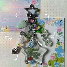 a star shaped keychain with charms hanging from it's side on a table