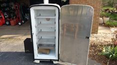 an old refrigerator is sitting outside in the driveway