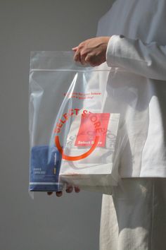 a person holding a plastic bag with an orange circle on it