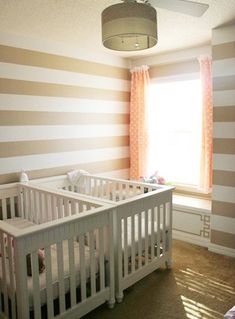 a baby's room with striped walls and white crib