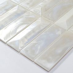 a close up view of a white glass tile pattern on a table with no one around it