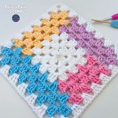 a crocheted square is shown with scissors and yarn