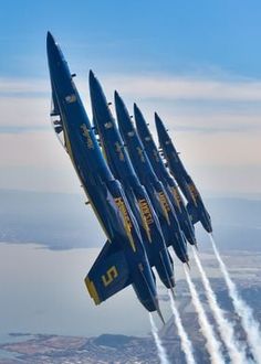 four blue angels jet team flying in formation