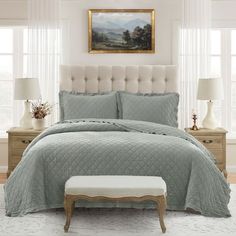 a bedroom with a large bed covered in a light blue comforter and matching pillows