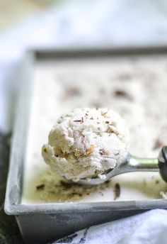 a scoop of ice cream sitting on top of a white plate next to a spoon