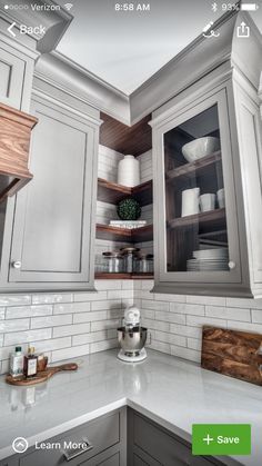 a kitchen with gray cabinets and white counter tops