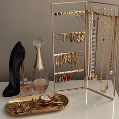 there is a gold jewelry rack and shoes on the table