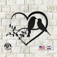 two birds sitting on a tree branch in the shape of a heart with an american flag sticker