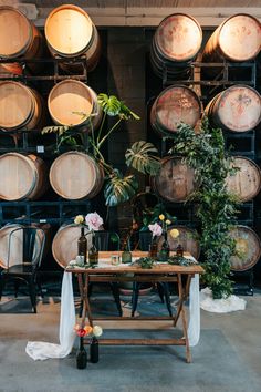 a table surrounded by wine barrels and plants