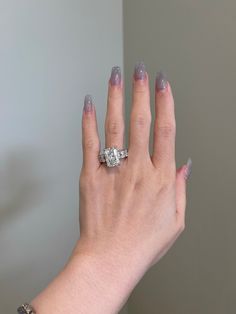 a woman's hand with two rings on it and a diamond in the middle