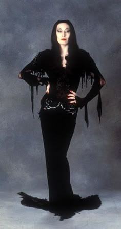 an image of a woman with long hair wearing black clothing and holding her hands on her hips