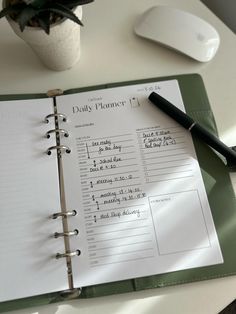 a daily planner sitting on top of a desk next to a computer mouse