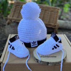 a crocheted hat and booties are sitting on top of a cardboard box