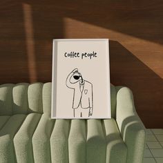 there is a sign that says coffee people on the back of a green couch in front of a wood paneled wall