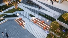 an aerial view of people walking and sitting on benches in the middle of a courtyard