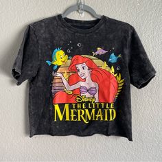 the little mermaid t - shirt hanging on a wall