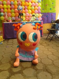 an orange stuffed animal sitting on the floor in front of balloons