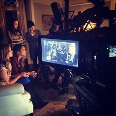 a group of people standing around a television