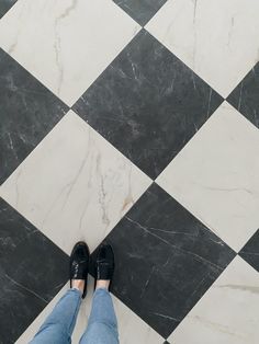 a person standing on a checkered floor with black and white tiles in the background