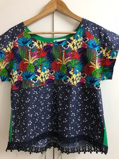 I found this lovely and colourful jungle inspired fabric piece and I envisioned it made into a fun and bright tee. The fabric has been teamed with a contrasting blue/gray light floral and a touch of bright green to create this size 10 boho tee.  This style has a pleat from the back yoke for a relaxed style and sits on or just below the waistline and trimmed at the hem line with matching lace.  The tee could be worn alone or worn over a long sleeved tee with jeans or relaxed pants in the cooler weather. This tee comfortably fits - bust 89-91cm, waist 71-76cm and hips 94-96cm and is priced at $54.95 with free postage in Australia. Casual Tops With Multicolor Mixed Print, Cotton Tops With Vibrant Print, Tropical Multicolor Tops With Tropical Print, Summer Cotton Tops With Mixed Print, Casual Blue Tops With Mixed Print, Cotton Tops With Mixed Print, Fun Green Printed Tops, Vibrant Cotton Tops, Blue Casual Tops With Mixed Print