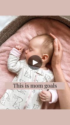 a baby laying on top of a pink blanket with the words, this is mom goals