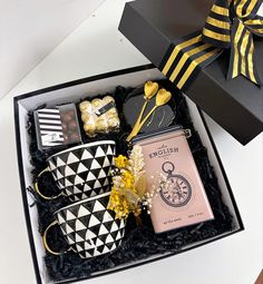 a gift box with coffee mugs and sweets