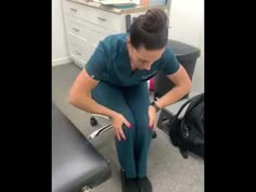 a woman sitting in an office chair with her foot on the desk and looking down