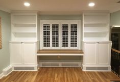 an empty room with white built - in cabinets and wood flooring, along with hard wood floors