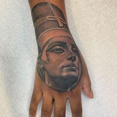 a man's hand with a tattoo on it that has an egyptian mask on it