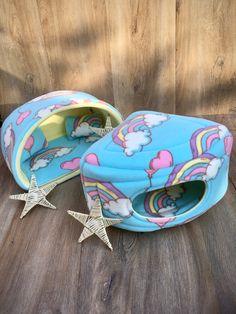 a pair of blue slippers with rainbows and stars on them sitting on top of a wooden floor