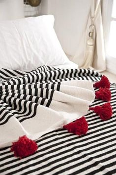 black and white striped bed with red pom poms