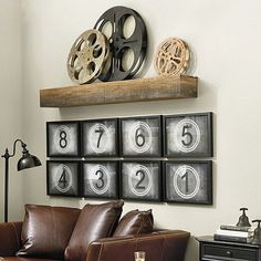 a brown leather couch sitting in front of a wall mounted movie projector on top of a wooden shelf