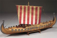 a wooden model of a viking boat with red and white stripes on the front sail