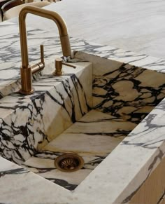 a marble sink with two faucets in it