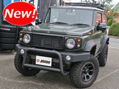 a green land rover parked in a parking lot with a red sign that says new