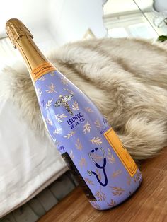 a bottle of wine sitting on top of a wooden table next to a fur covered bed