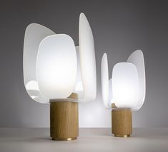 three white lamps sitting on top of wooden bases