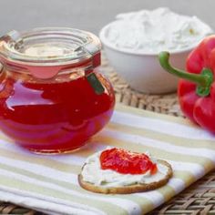 there is a jar of jelly next to some tomatoes and crackers on the table