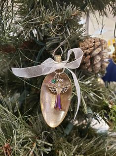 an ornament hanging from a christmas tree with pine cones and other decorations in the background