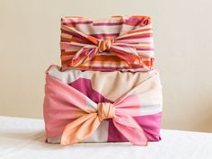 three bags with bows are stacked on top of each other in different colors and patterns