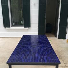 a blue table sitting on top of a tiled floor