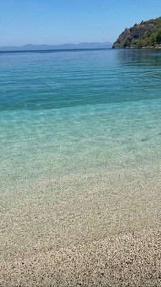 an empty beach with clear blue water