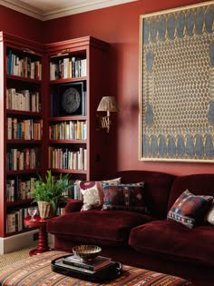 a living room with bookshelves, couch and coffee table in front of it