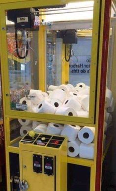 a vending machine filled with lots of rolls of toilet paper next to a sign that says you've got to be kidding me