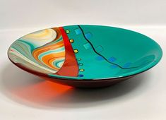 a colorful bowl sitting on top of a white table